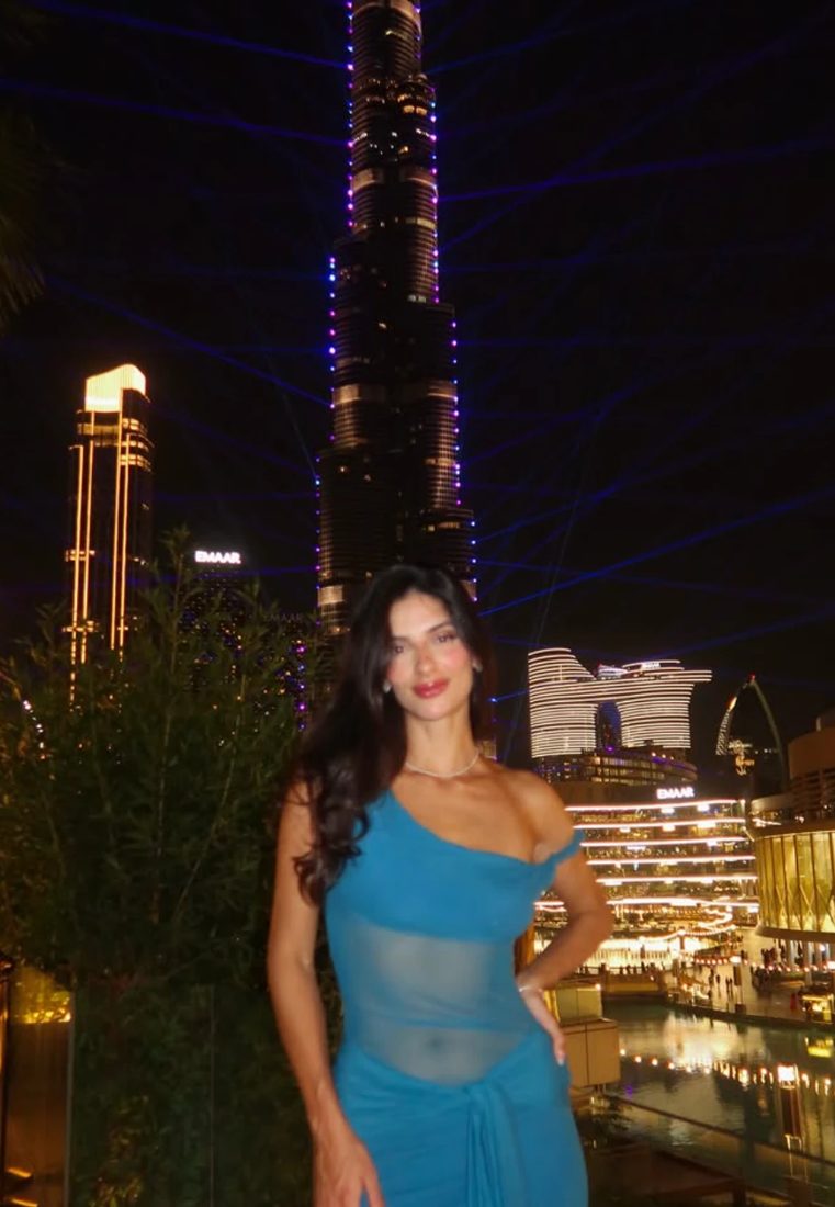 Aurea em Dubai, à noite, com o Burj Khalifa ao fundo